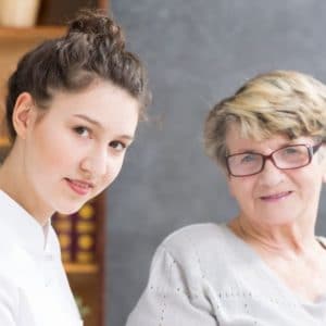 Junge Pflegekraft mit älterer Dame