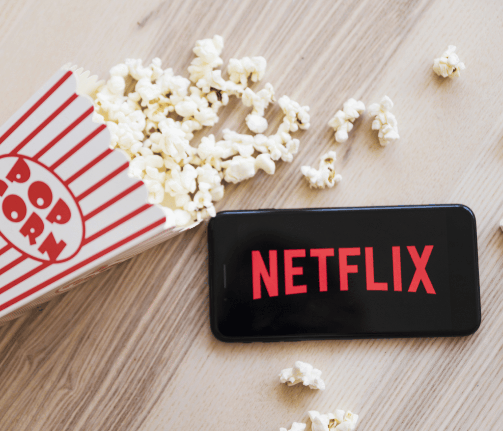 Pflege auf Netflix: Popcorn und Handy mit Netflix Logo