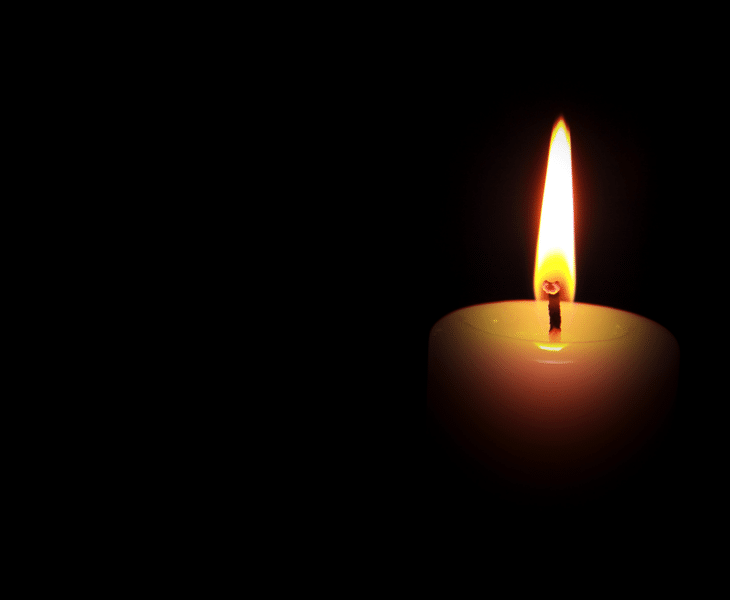 Symbolbild: Suizid in der Pflege: Wenn Kolleg*innen sich das Leben nehmen: brennende Kerze vor schwarzem Hintergrund