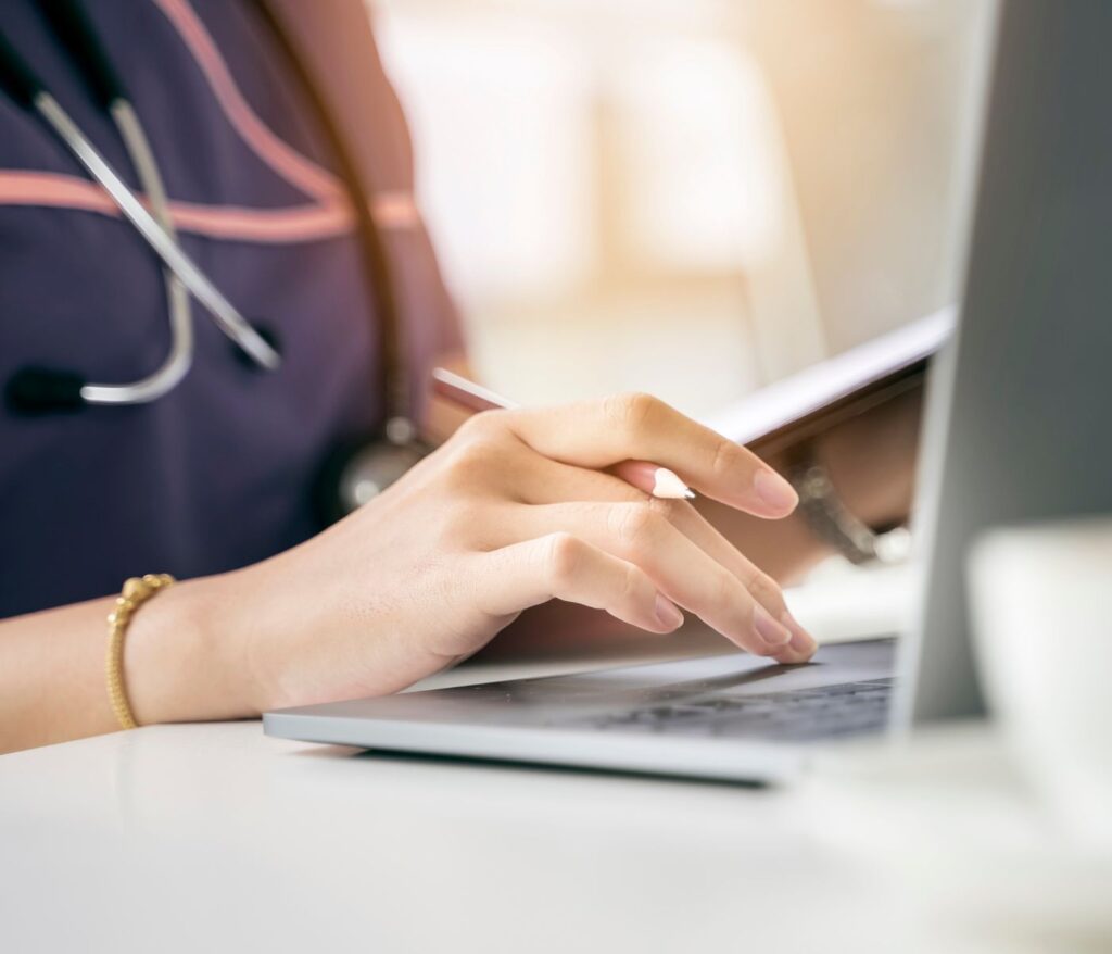 Symbolbild: Die perfekte Webseite - Tipps für Pflegeeinrichtungen vom Experten: Eine Pflegekraft bedient einen Laptop.